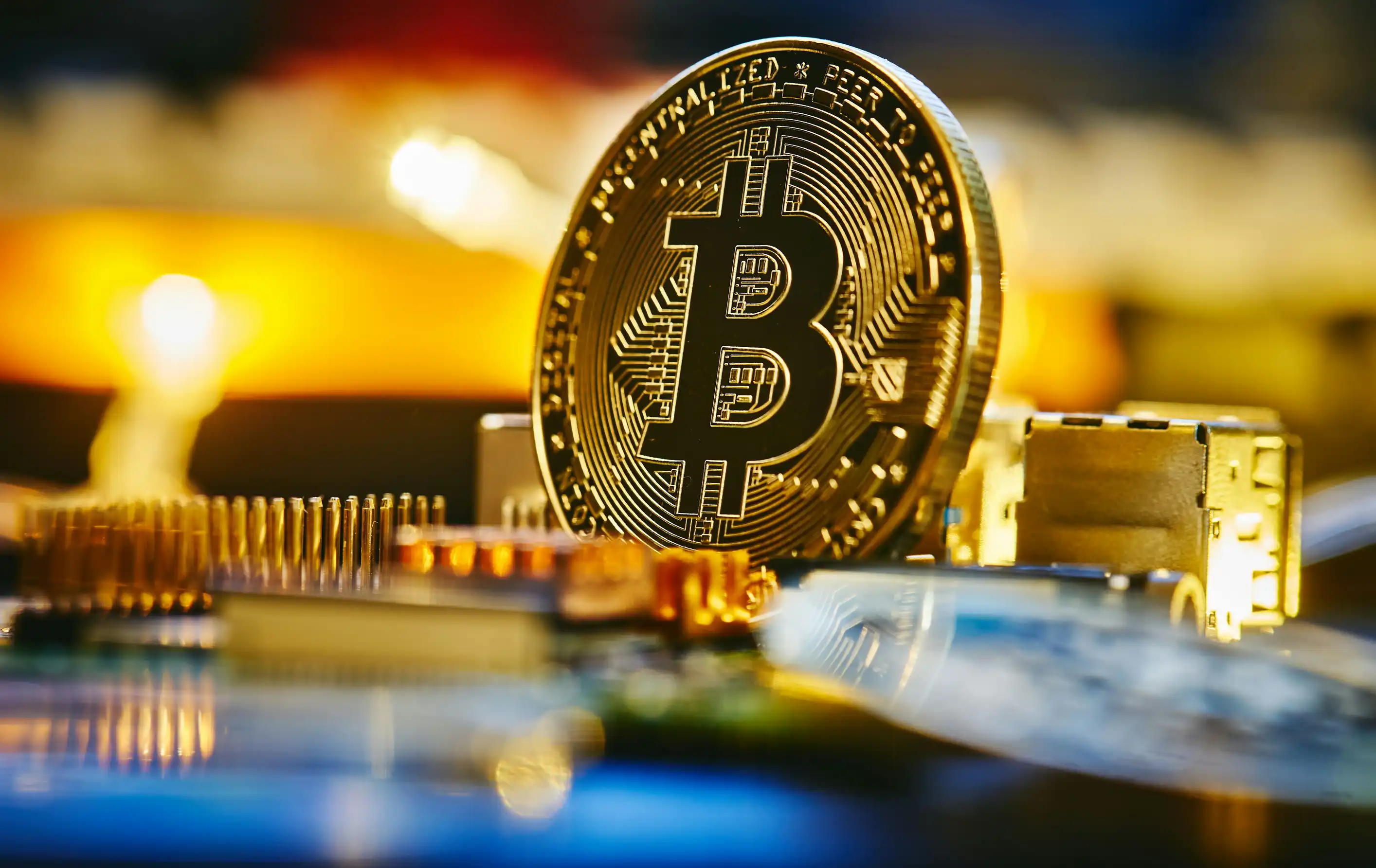 Bitcoin-mynt på en databrikke med varm bakgrunnsbelysning