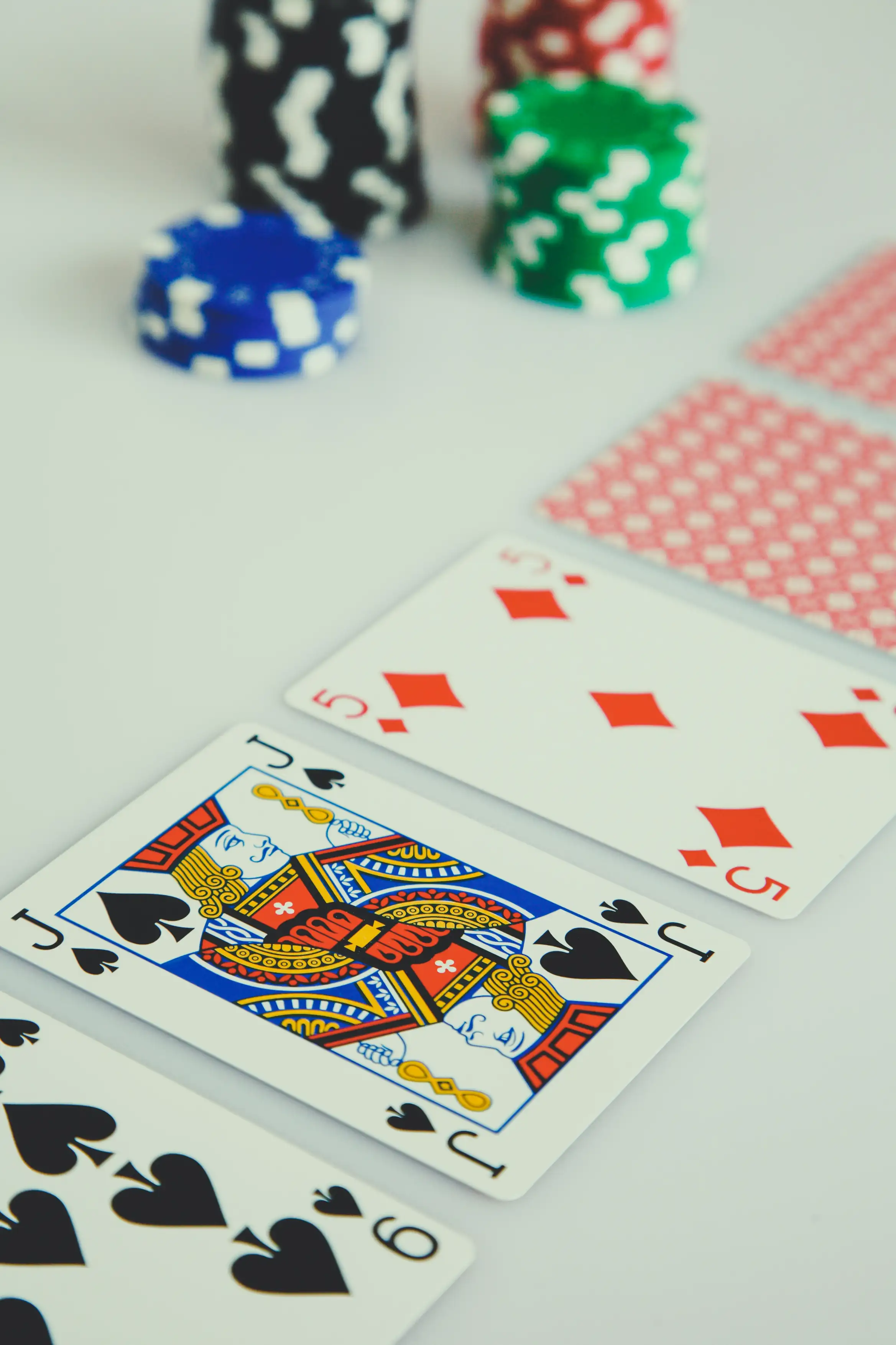 Spillkort og casinochips på et lyst spillebord