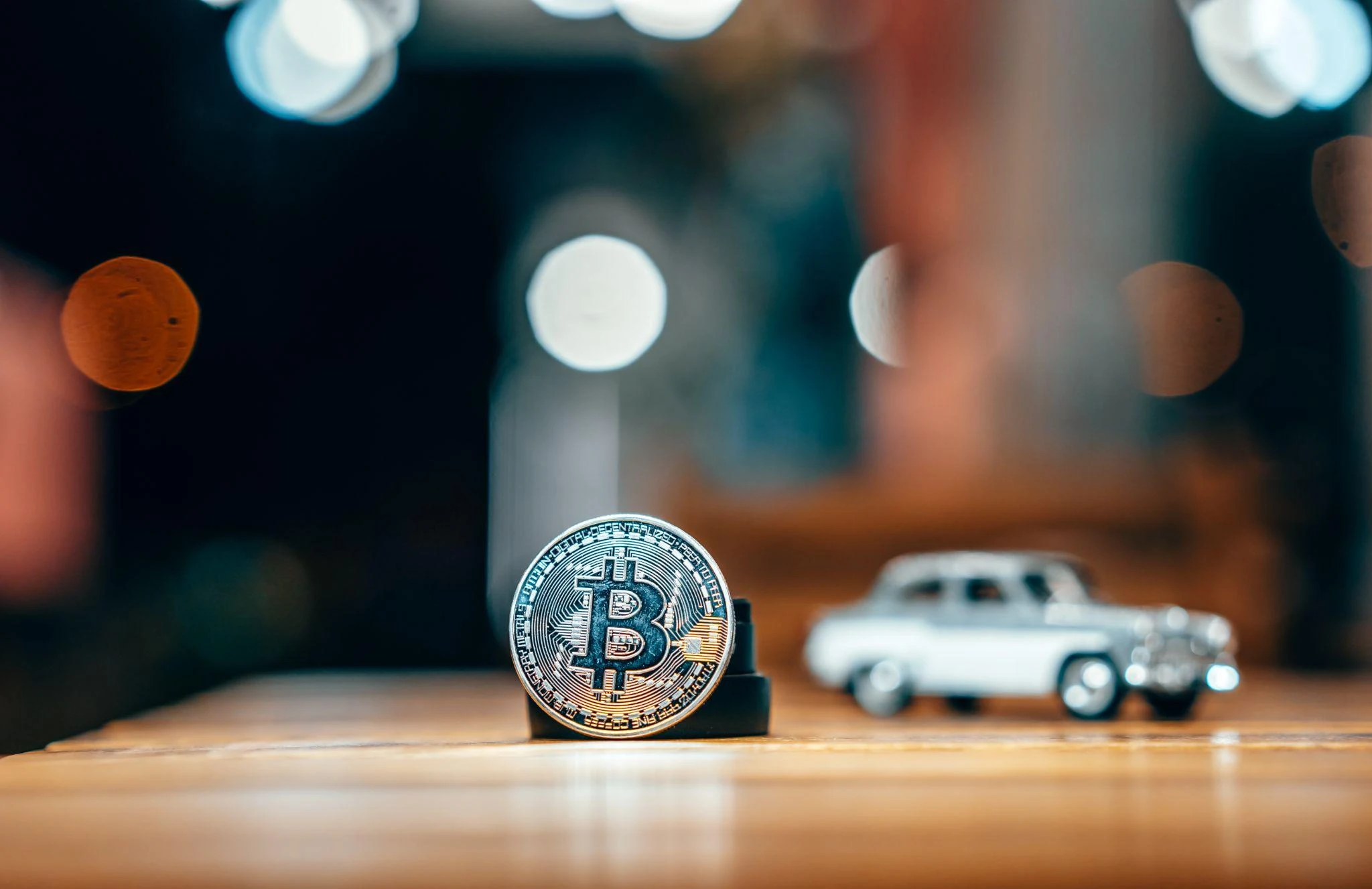 Bitcoin-mynt med miniatyrbil i bakgrunnen